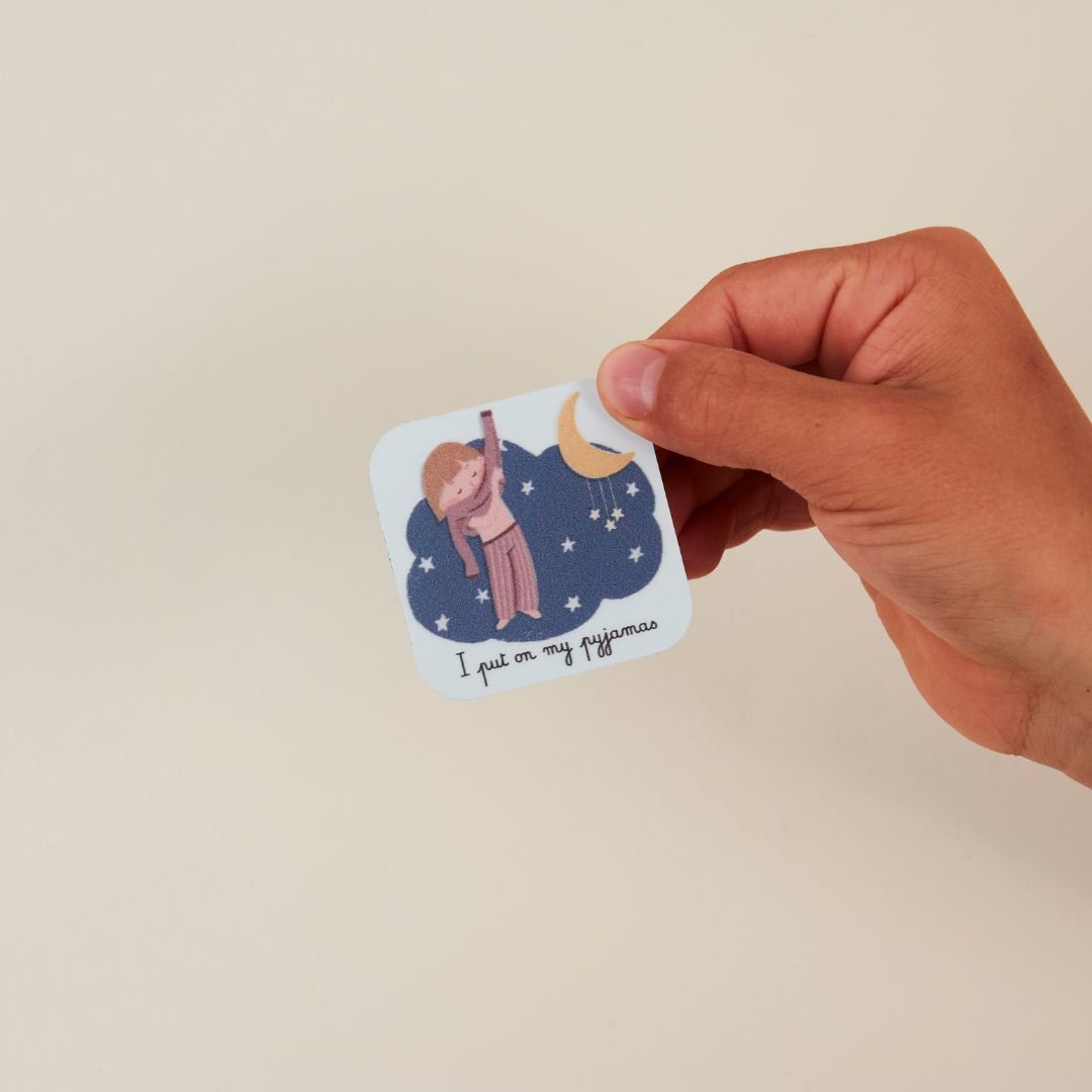 main qui tient le magnet pyjama de la routine du soir en anglais