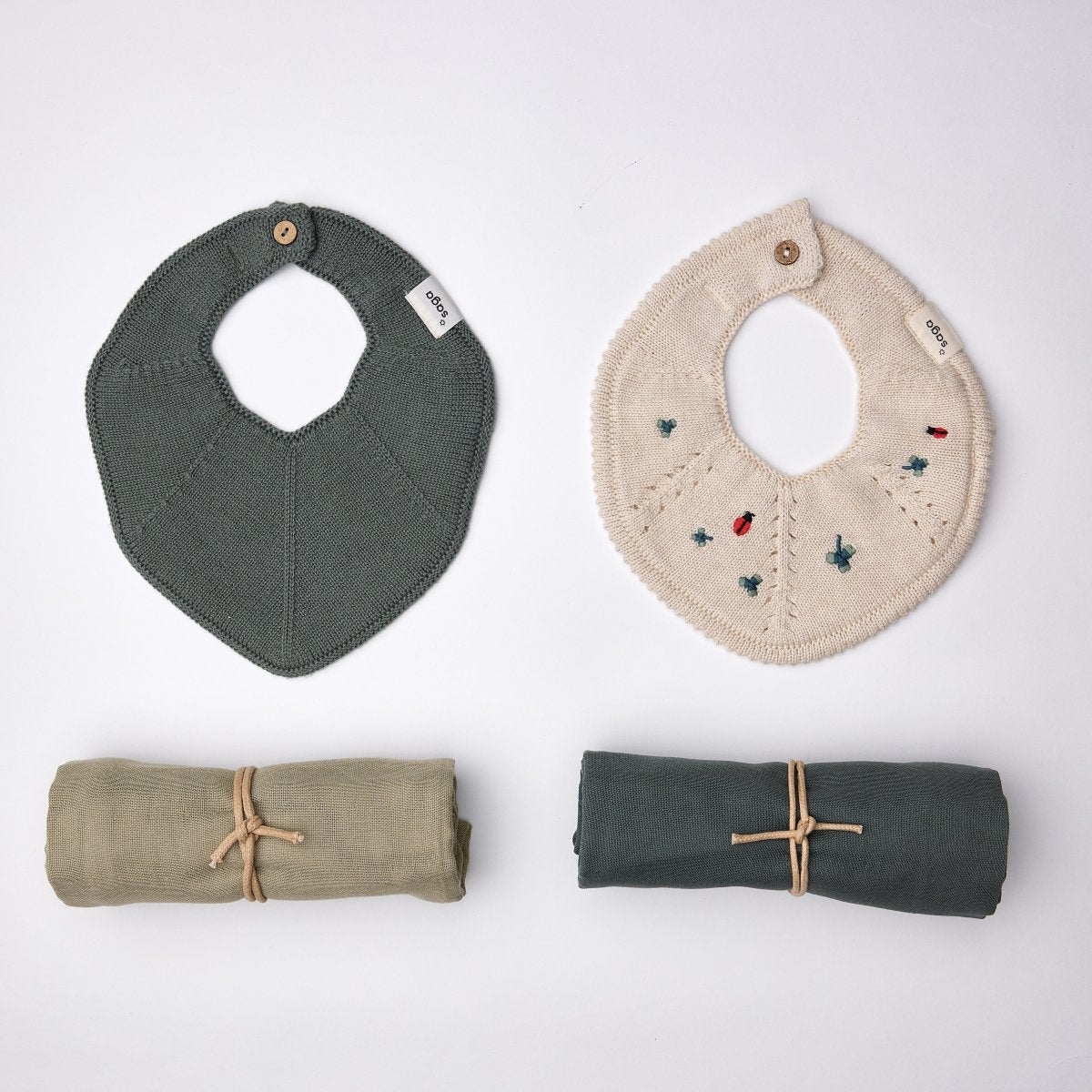 saga copenhagen must-have baby gift box green clover, contents laid out next to each other: teething bibs and muslin cloths in clover and forest green